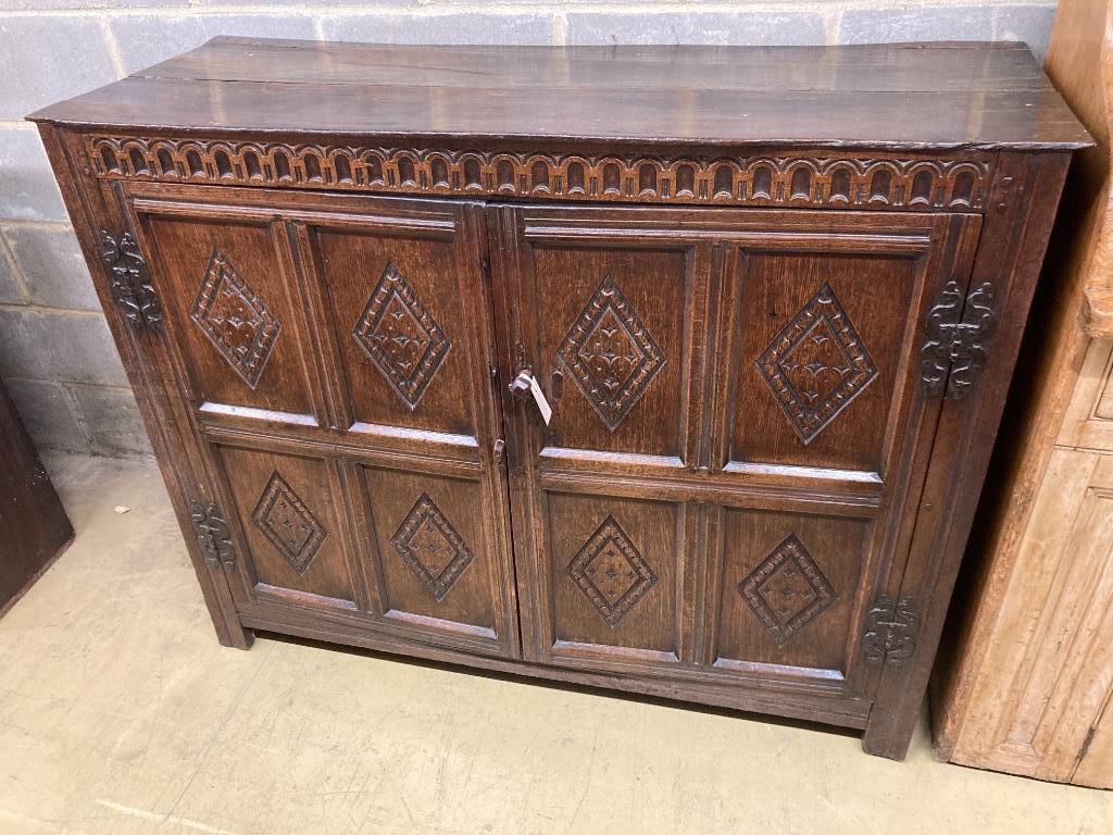 A 17th century carved and panelled oak cupboard
